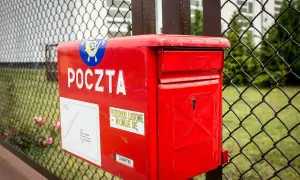 Czerwona skrzynka pocztowa z napisem "POCZTA" i naklejką "PRZESYŁKI LISTOWE WYJMUJE SIĘ". Czyżby naruszenie tajemnicy korespondencji?