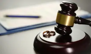 Młotek sędziowski i obrączki symbolizują rozwód, nawet gdy dziecko ma innego partnera.