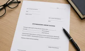 Dokument "Wypowiedzenie umowy zlecenia" leży na drewnianym biurku obok okularów i długopisu.