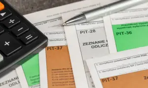 Kalkulator i długopis leżą na dokumentach PIT-37, PIT-28 i PIT-36. Czas na rozliczenie podatku i skorzystanie z ulg, czyli ikze odliczenie od podatku.