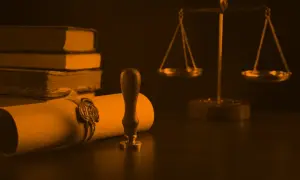 Zapieczętowany dokument, waga sprawiedliwości i księgi symbolizują ostatnią wolę zmarłego.