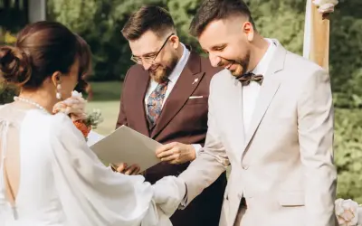 Uroczystość ślubu cywilnego, podczas której para młoda wymienia obrączki. W tle urzędnik udzielający ślubu.