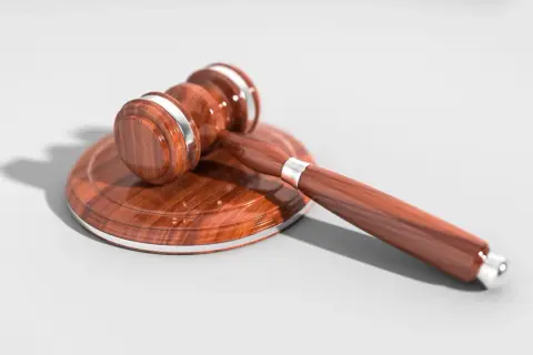 Drewniany młotek sędziowski na tle, symbol sprawiedliwości i testamentu.