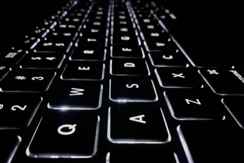 Klawiatura laptopa z podświetlanymi klawiszami. Litery Q, W, E, R, T, Y, U, I, O, P, A, S, D, F, G, H, J, K, L, Z, X, C, V, B, N, M. Co to jest netto?