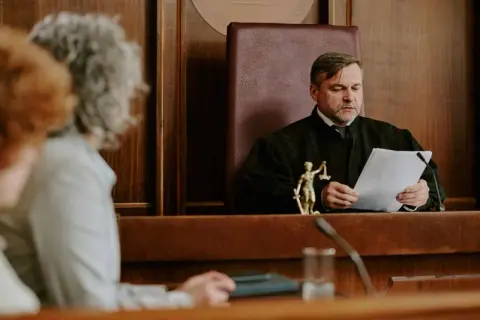 Sędzia w todze analizuje dokumenty, zastanawiając się, o co pyta sąd w sprawie o zachowek.