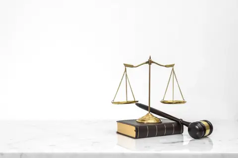 Waga sprawiedliwości, młotek sędziowski i księga prawa. Symbolizują sprawiedliwy proces, który może zadecydować o tym, kto zostanie jedynym spadkobiercą testamentowym.