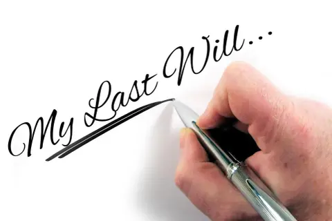 Dłoń pisze długopisem "My Last Will...", myśląc o przyszłości dzieci i testament wzajemny.