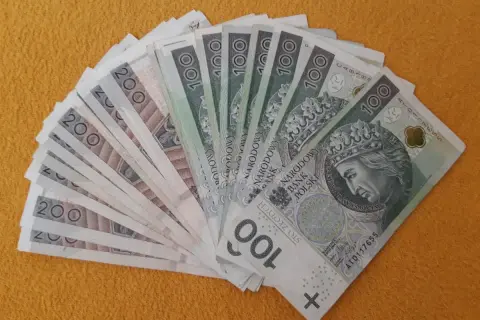 Darowizna spadku na rzecz siostry: stos banknotów 100 i 200 zł ułożony wachlarzem.