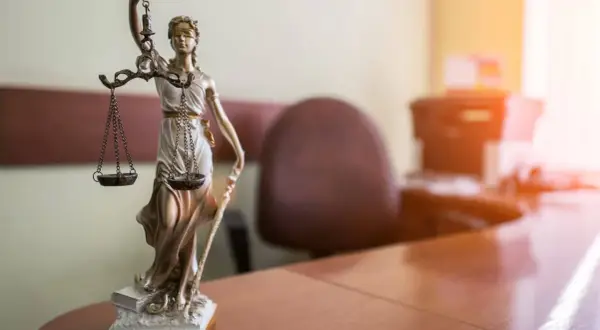 Figurka Temidy na biurku. Czy darowizna po ślubie wchodzi do majątku wspólnego? Prawo i sprawiedliwość.
