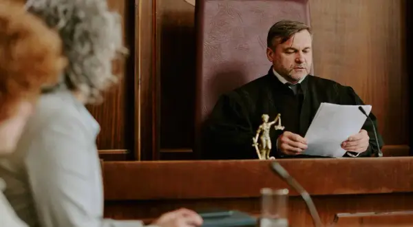 Sędzia w todze analizuje dokumenty, zastanawiając się, o co pyta sąd w sprawie o zachowek.