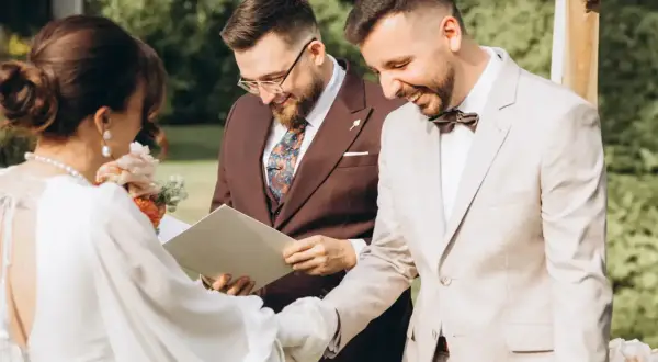 Uroczystość ślubu cywilnego, podczas której para młoda wymienia obrączki. W tle urzędnik udzielający ślubu.