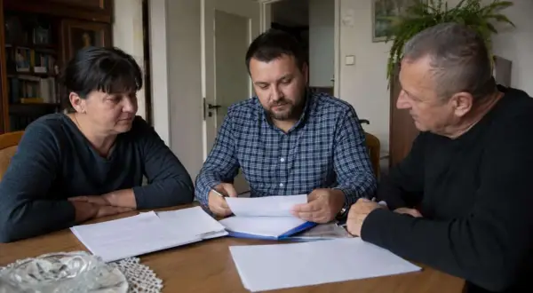 Rodzina przy stole omawia dokumenty. Czy u notariusza muszą być wszyscy spadkobiercy?