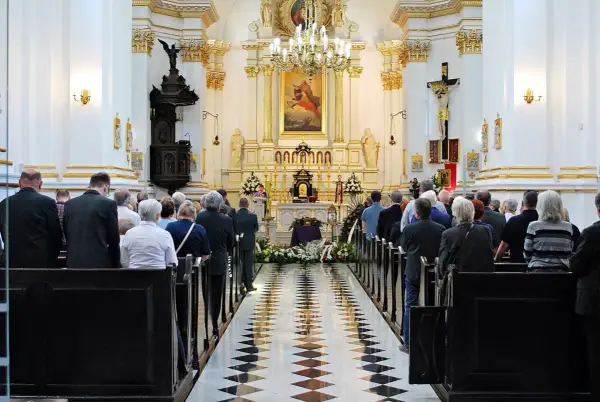 Uroczystość pogrzebowa w kościele. Rodzina i przyjaciele żegnają zmarłego. Warto pamiętać o zasiłku pogrzebowym i zwrocie kosztów pogrzebu z banku.