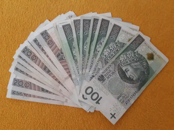 Darowizna spadku na rzecz siostry: stos banknotów 100 i 200 zł ułożony wachlarzem.
